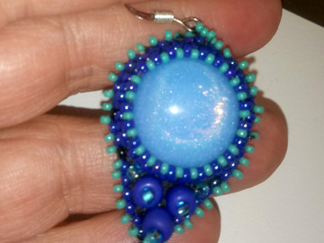 Sale retail: Boucles  en perles brodées bleues autour d'une opaline