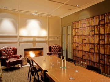 Book a meeting | $: The Library | A cosy private meeting room featuring a fireplace