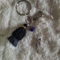 Sale retail: Porte clé avec pompon noir, gris et blanc révolver 